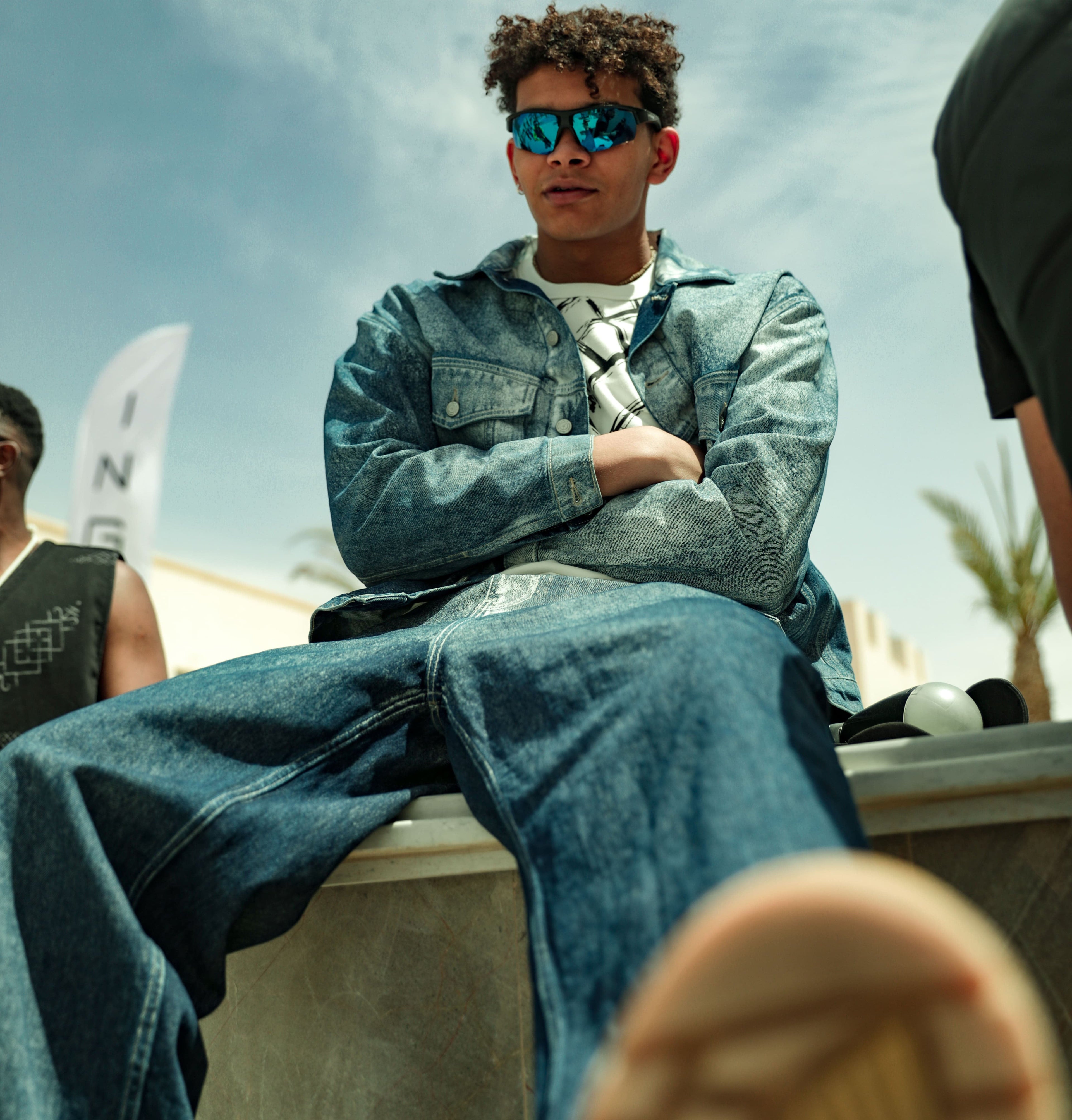 Mannequin portant un ensemble en denim KONTAKT à coupe ample, photographié en extérieur lors de la Tunis Fashion Week