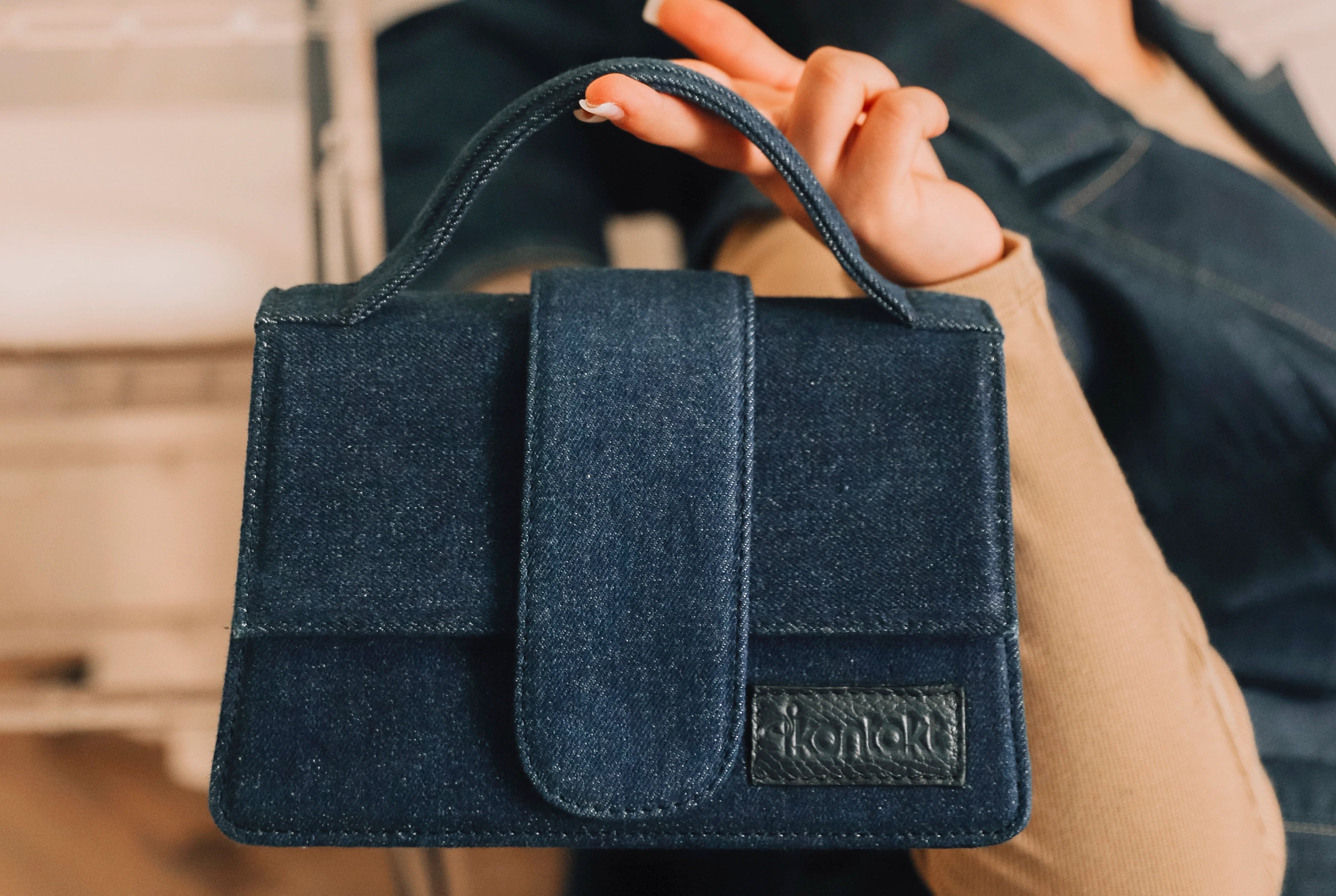 Sac en denim KONTAKT fabriqué à partir de tissus de surplus, réalisé par des artisans, photographié en gros plan porté à la main